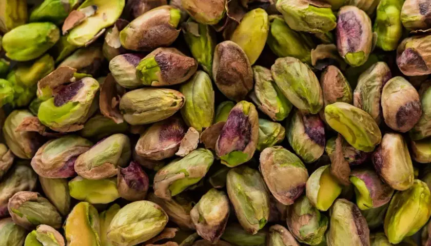 Mnóstwo łuskanych pistacji, zielonych i brązowych. Czy psy mogą jeść pistacje? Lepiej nie ryzykować.