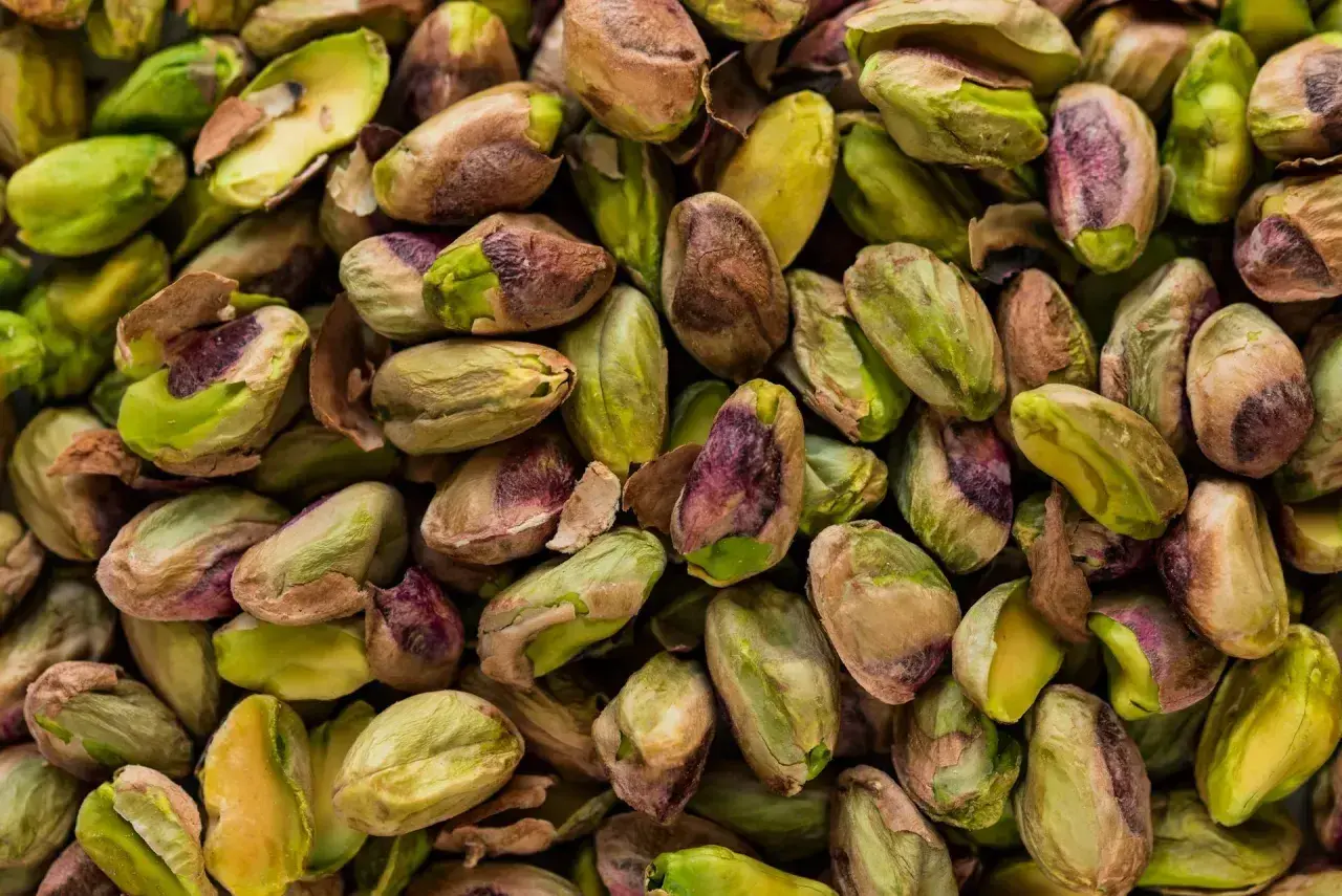 Mnóstwo łuskanych pistacji, zielonych i brązowych. Czy psy mogą jeść pistacje? Lepiej nie ryzykować.